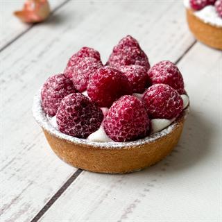 Заварной крем, взбитые сливки и спелая малина в корзиночке из песочного теста.