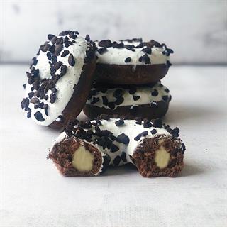  Пончик c ванильной начинкой, белой глазурью и кусочками печенья.