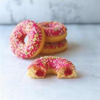 Пончик с клубничной начинкой и розовой кондитерской глазурью с цветной посыпкой