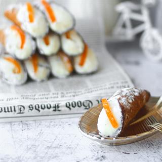 Хрустящая трубочка, покрытая изнутри шоколадом, заполнена начинкой - легким кремом на основе сыра Рикотта. Край трубочки украшен апельсиновыми цукатами.