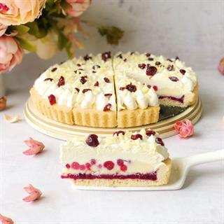 Пирог с брусничной начинкой и начинкой из белого шоколада, брусникой, взбитыми сливками, украшенный белом шоколадом и клюквой.