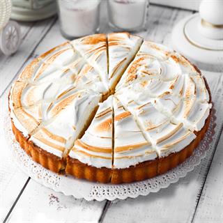 Лимонный торт с кремом и меренгой на подложке из песочного теста.