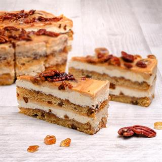 Между воздушных бисквитов с грецкими орехами две прослойки из нежного крема с корицей и карамелью. Сверху полит толстым слоем карамели с корицей и украшен горстью грецких орехов. 