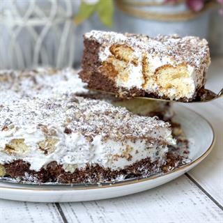 Белый и шоколадный бисквиты, прослоенные сметанным кремом. Торт украшен дроблёным орехом.