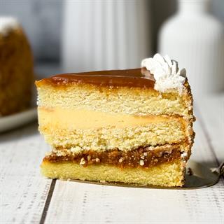 Бисквитный ванильный торт со слоем соленой хрустящей карамели и сливочного крема с молотыми стручками бурбонской ванили, покрыт толстым слоем карамели.